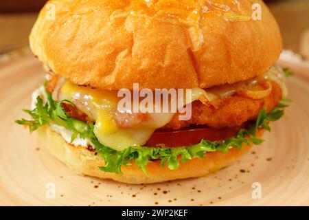 Cheeseburger garni de laitue et de différentes garnitures placées sur une assiette, prêt à être dégusté. Banque D'Images