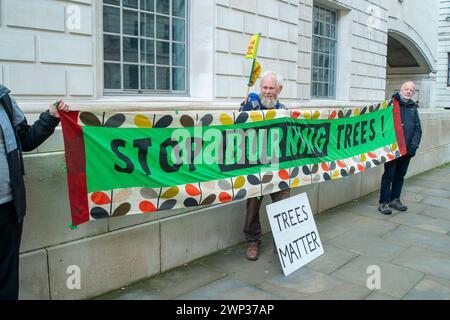 Whitehall, Londres, Royaume-Uni. 5 mars 2024. Des manifestants de Money Rebellion, extinction Rebellion, Biofuelwatch, la Coalition Stop Burning Trees, Greenpeace, Stop Rosebank et la campagne contre le changement climatique ont organisé une manifestation d'urgence Stop Drax devant le ministère de l'énergie, de la sécurité et du Net Zero aujourd'hui à Londres. Les manifestants déclarent : « le gouvernement britannique envisage actuellement de donner des milliards de livres de plus en subventions à la centrale polluante de Drax et Lynemouth. S'il est approuvé, le Royaume-Uni enfermera dans des années plus de brûler des arbres au détriment de nos forêts, de la santé et de l'énergie b Banque D'Images