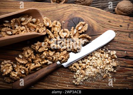 Noyaux de noix de noix écrasées et couteau sur la plaque de bois en gros plan. Photographie culinaire Banque D'Images