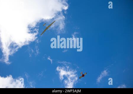 Planeur blanc tiré par un autre petit avion vers le ciel bleu. Planeur tirant sur une journée ensoleillée. Banque D'Images