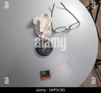 Une collection disparate d'objets éventuellement optiques qui se sont rassemblés sur une table circulaire bleu pâle lors d'une séance photo en intérieur. Banque D'Images