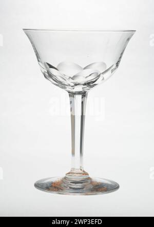 Ce verre à vin, produit entre 1900 et 1910, est un récipient à boire du début du XXe siècle. Il est fait de verre clair, avec une tige et un bol conçus pour servir le vin, reflétant le style et l'artisanat de l'époque. Banque D'Images