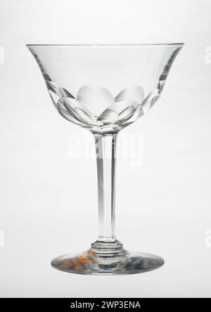 Ce verre à vin, produit entre 1900 et 1910, est un récipient à boire du début du XXe siècle. Il est fait de verre clair, avec une tige et un bol conçus pour servir le vin, reflétant le style et l'artisanat de l'époque. Banque D'Images