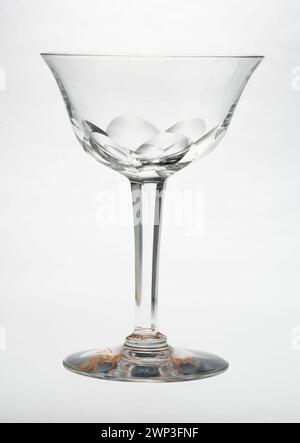 Ce verre à vin, produit entre 1900 et 1910, est un récipient à boire du début du XXe siècle. Il est fait de verre clair, avec une tige et un bol conçus pour servir le vin, reflétant le style et l'artisanat de l'époque. Banque D'Images