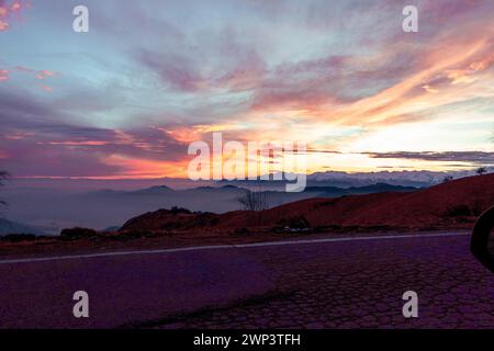 Coucher de soleil dans les montagnes. Ciel orange et nuances indigo. Coucher de soleil suggestif de la montagne Mottarone, avec Monviso en arrière-plan et chaîne de montagnes. Banque D'Images