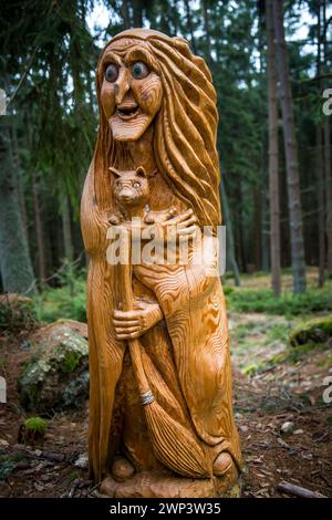 Figure en bois d'une sorcière et de son chat dans la 'forêt hantée' (Zauberwald Scheiben) - Waldviertel, Naturpark Scheiben (Bad Großpertholz) Banque D'Images