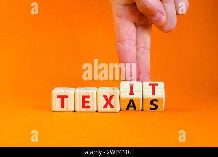 Symbole Texas ou Texit. Mot concept Texas ou Texit sur de beaux cubes en bois. Belle table orange fond orange. Main d'homme d'affaires. Business Tex Banque D'Images