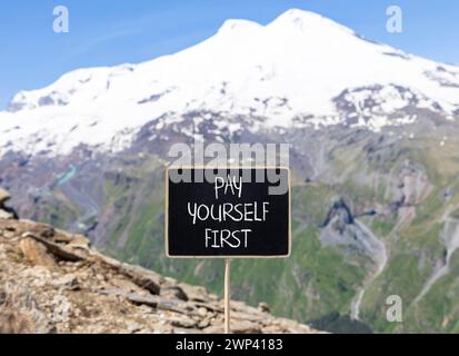 Premier symbole payez-vous. Les mots de concept vous payez d'abord sur un beau tableau noir de craie noire. Beau fond de montagne Elbrus. Affaires et PA Banque D'Images