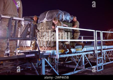 Lieu non divulgué, États-Unis. 5 mars 2024. Des aviateurs du port aérien de l'armée de l'air américaine et des gréeurs de parachutistes de l'armée américaine introduisent des palettes d'aide humanitaire destinées à Gaza sur un chargeur K à un endroit non divulgué dans la zone de responsabilité du commandement central des États-Unis, le 5 mars 2024. La capacité de mobilité mondiale rapide de l'armée de l'air américaine a permis d'accélérer le transport de fournitures vitales essentielles vers Gaza. (Crédit image : © U.S. Air Force/ZUMA Press Wire) USAGE ÉDITORIAL SEULEMENT! Non destiné à UN USAGE commercial ! Banque D'Images