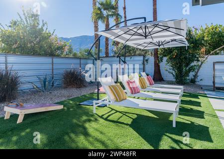 Chaises longues de jardin avec parasols et soleil à Palm Springs, Californie Banque D'Images