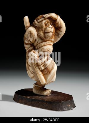 Sculpture de netsuke intitulée 'Little King', XIXe siècle, montée sur un support en bois, représentant une figure en pose dynamique. Banque D'Images