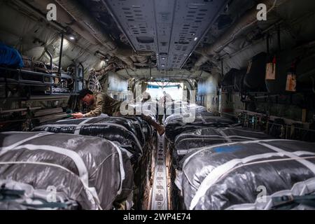 Lieu non divulgué, États-Unis. 5 mars 2024. Les capitaines de chargement de l'US Air Force et les gréeurs de parachutistes de l'US Army à bord d'un C-130J Super Hercules inspectent des parachutes reliés à des palettes d'aide humanitaire destinées à Gaza à un endroit non divulgué dans la zone de responsabilité du commandement central des États-Unis, 5 mars 2024. L'opération conjointe américaine comprend une série d'inspections pour s'assurer que les palettes sont préparées en toute sécurité et prêtes pour les opérations de largage aérien. (Crédit image : © U.S. Air Force/ZUMA Press Wire) USAGE ÉDITORIAL SEULEMENT! Non destiné à UN USAGE commercial ! Banque D'Images