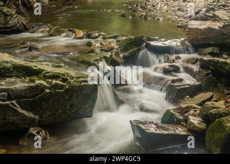 Gros plan de l'eau d'un petit ruisseau de montagne en cascade sur des rochers et des rochers en Corée du Sud Banque D'Images