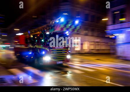 MALMO, SUÈDE - 25 OCTOBRE 2014 : camion de pompiers Scania conduisant très rapidement dans les rues nocturnes de la ville de Malmo, fort effet de flou de mouvement Banque D'Images