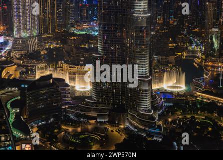 Une photo du Dubai Fountain Show, la nuit, et le fond de la Burj Khalifa, à côté d'autres bâtiments du centre-ville de Dubaï. Banque D'Images