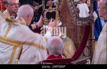 King Charles III Crown couronnement moment, avec la Couronne de besoin Edward positionné par l'archevêque Justin Welby dans l'abbaye de Westminster avec le roi Charles III assis dans la chaise du couronnement Westminster Londres Royaume-Uni la Couronne de Saint-Édouard est la pièce maîtresse des joyaux de la Couronne du Royaume-Uni. Nommé d'après Saint Édouard le Confesseur, des versions de celui-ci ont traditionnellement été utilisées pour couronner les monarques anglais et britanniques lors de leurs couronnements depuis le XIIIe siècle. (Capture de diffusion UHDTV améliorée) Banque D'Images