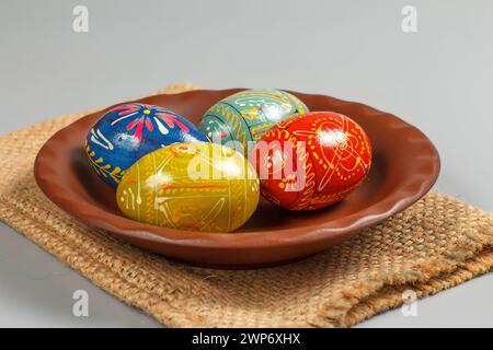 Assiette en argile avec des oeufs de Pâques peints sur le sac de sac. Banque D'Images