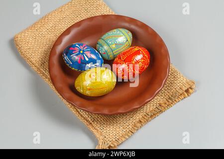 Assiette en argile avec des oeufs de Pâques peints sur le sac de sac. Vue de dessus. Banque D'Images