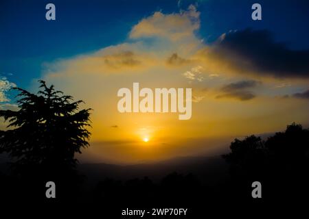 Vue sur le coucher du soleil depuis les montagnes de Lansdowne. Vue sur le coucher de soleil de la montagne à Lansdowne. Incroyable coucher de soleil doré vu à travers la route de la forêt, Lansdowne Uttarakhan Banque D'Images