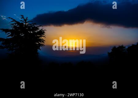 Vue sur le coucher du soleil depuis les montagnes de Lansdowne. Vue sur le coucher de soleil de la montagne à Lansdowne. Incroyable coucher de soleil doré vu à travers la route de la forêt, Lansdowne Uttarakhan Banque D'Images