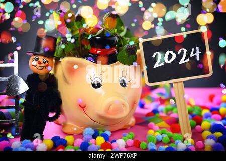 FOTOMONTAGE, Glücksschwein mit Kleeblättern, Schornsteinfegerfigur und Schild mit Aufschrift 2024 Banque D'Images