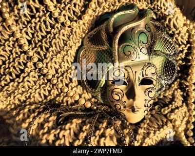 Masque de carnaval sur un fond tricoté avec des perles et des étincelles. Elément de costume de fête de carnaval. Contraste élevé Banque D'Images