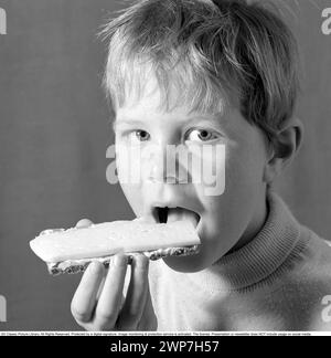 Dans les années 1960 Un garçon mange un sandwich au fromage. 1969. Conard ref 5818 Banque D'Images