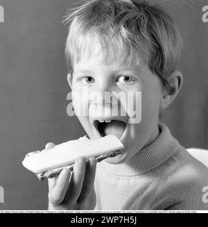 Dans les années 1960 Un garçon mange un sandwich au fromage. 1969. Conard ref 5818 Banque D'Images