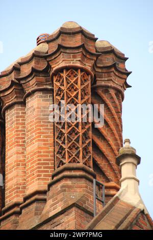 Un bâtiment en briques rouges avec des ornements métalliques complexes sur le toit à Londres Banque D'Images