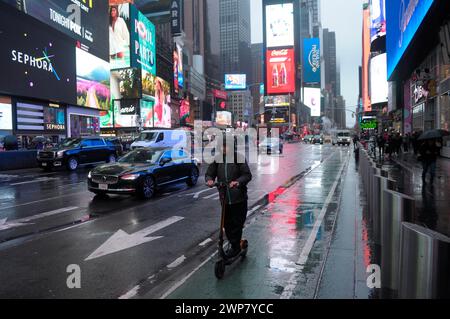 New York, États-Unis. 05 mars 2024. Une personne conduit un scooter électrique à travers Times Square, New York City un jour de pluie. (Photo de Jimin Kim/SOPA images/SIPA USA) crédit : SIPA USA/Alamy Live News Banque D'Images