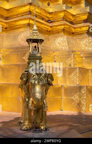 Vue verticale de sculpture d'éléphant doré sur la base du stupa principal à l'ancien temple bouddhiste de Wat Chom Phu ou Chomphu, Chiang mai, Thaïlande Banque D'Images