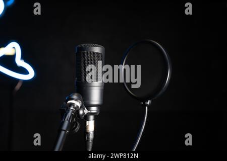 Gros plan d'un microphone de studio à condensateur professionnel sur un fond noir dans un studio de musique. Banque D'Images