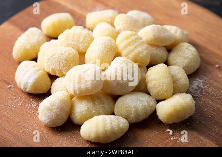 Tas de gnocchi crus sur une planche à découper en bois Banque D'Images