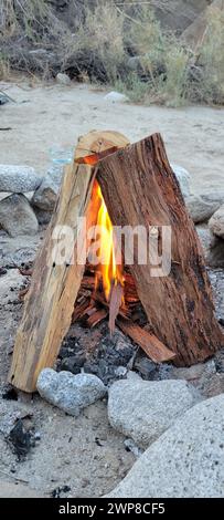 Un feu allumé par des rochers et du bois sur la plage Banque D'Images