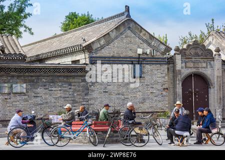 Hommes âgés assis et parlant sur la place dans la ville de Yangliuqing à Tianjin, Chine Banque D'Images