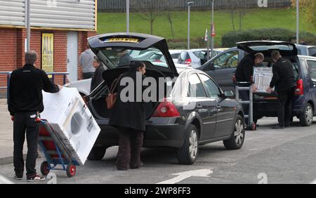 08/11/12 le personnel de Comet charge les machines à laver dans les voitures des clients en attente. Les acheteurs affluent au magasin Comet à Derby après que le magasin ait déclenché un incendie Banque D'Images