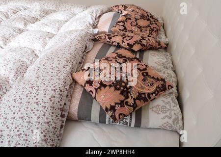 Oreillers décoratifs roses sur le linge de lit. Lit double de mariage avec oreillers et couette en plumes épaisse. Design de la chambre. Tête de lit blanche et douce. Intérieur avec Banque D'Images