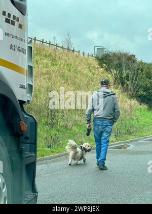 Ipswich, Suffolk - 14 février 2024 : retards importants sur l'A14 en direction ouest à Nacton. Route fermée en raison d'un incident géré par la police. Un homme promène son chien sur l'épaule dure. Banque D'Images