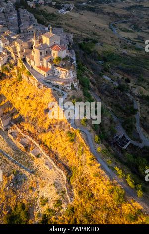 Vue aérienne de l'ancienne ville de Petralia Soprana, construite sur une falaise, au coucher du soleil. Palerme district, Sicile, Italie. Banque D'Images