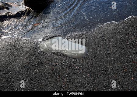 Grande roche volcanique lisse sur la plage de sable volcanique rugueux noir el golfo, Lanzarote, Îles Canaries, espagne Banque D'Images