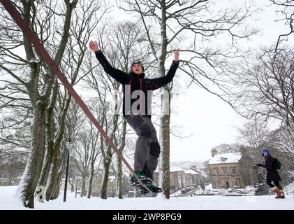 05/02/13 Matt Stevens, 19 ans, pratique la slackline à travers une ligne tendue entre les arbres à Buxton, Derbyshire lors de fortes chutes de neige. 'La neige donne un s. Banque D'Images