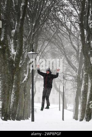 05/02/13 Matt Stevens, 19 ans, pratique la slackline à travers une ligne tendue entre les arbres à Buxton, Derbyshire lors de fortes chutes de neige. 'La neige donne un s. Banque D'Images