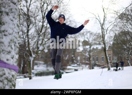 05/02/13 Matt Stevens, 19 ans, pratique la slackline à travers une ligne tendue entre les arbres à Buxton, Derbyshire lors de fortes chutes de neige. 'La neige donne un s. Banque D'Images