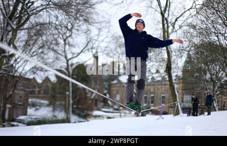 05/02/13 Matt Stevens, 19 ans, pratique la slackline à travers une ligne tendue entre les arbres à Buxton, Derbyshire lors de fortes chutes de neige. 'La neige donne un s. Banque D'Images