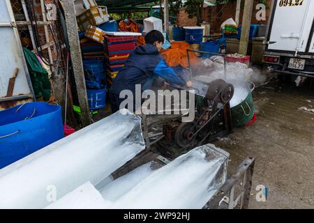 Ouvrier avec des blocs de glace au marché aux poissons de Hoi an Banque D'Images