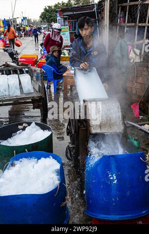 Ouvrier avec des blocs de glace au marché aux poissons de Hoi an Banque D'Images