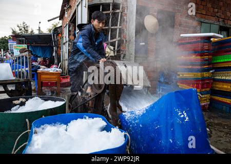 Ouvrier avec des blocs de glace au marché aux poissons de Hoi an Banque D'Images