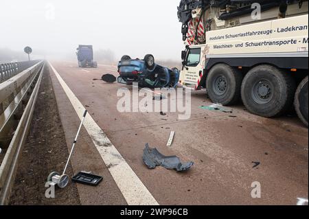 A14/Leipzig - Stau und Nebel : mehrere Verletzte BEI Massen-crash auf der Autobahn - Polizist kontrolliert Auto-Scheinwerfer im Stau 04.03.2024 gegen 6,30 Uhr A14 Richtung Magdeburg, zwischen Leipzig-Mitte und Leipzig-Nord Zu einem schweren Unfall kam am Montagmorgen auf der A14 Richtung Magdeburg BEI Leipzig. Nach ersten Angaben der Polizei und von Augenzeugen kam es aufgrund von Staubildung nach einem LKW-Unfall sowie durch starken Nebel am Morgen zu einem Unfall zwischen mindestens vier Fahrzeugen - darunter einem Lastwagen und einem LKW-Kran. Ein beteiligtes Auto überschlug sich und blie Banque D'Images