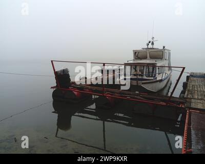 Belgrade, Serbie, 14 janvier 2020 bateau blanc à l'embarcadère, départ pour l'hiver. Temps brumeux un jour nuageux de janvier. Réflexion dans la rivière Banque D'Images