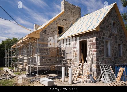 Travaux de restauration d'une ancienne maison en pierre de champ de style Canadiana des années 1800 en été, Montréal, Québec, Canada. Banque D'Images